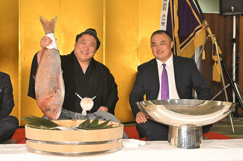 祝勝会で鯛を手に笑顔の若隆景(左)。右は荒汐親方