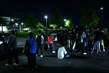 予定時刻になってもバスが到着せず待ちぼうけの報道陣