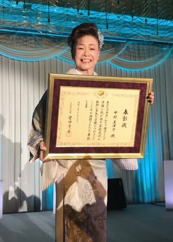 「令和二年度文化庁長官表彰」の表彰状をファンに披露する中村美律子
