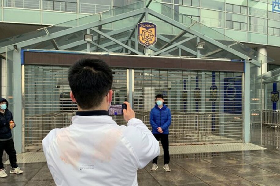  江蘇ＦＣの運営停止が決まりホームスタジアムの前で写真を撮るファン（ロイター）