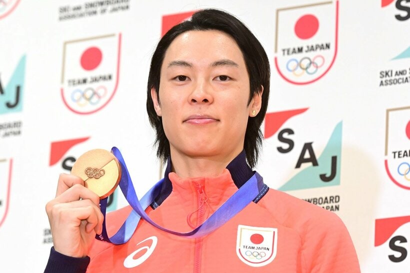 帰国会見でメダルを見せる小林陵侑