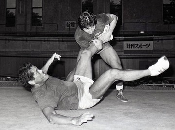 猪木（手前）の足を取りテークダウンを奪う前田（１９８６年９月、福島・棚倉町）