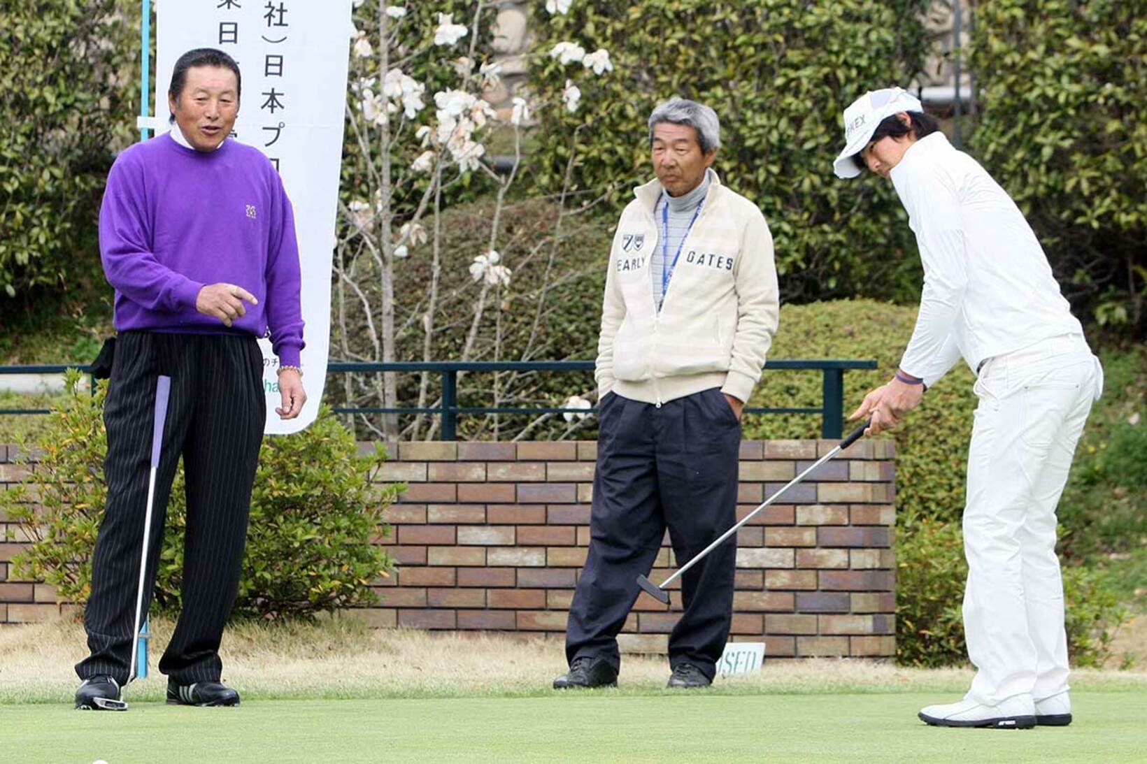 尾崎将司さん（左）からパットの指導を受ける石川遼