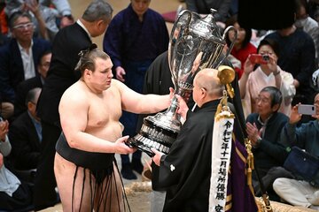 優勝し賜杯を受け取る安青錦（左）