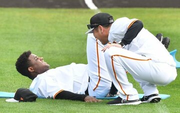  足上げ腹筋をサボるデラロサ(左)にお仕置きする巨人・元木ヘッド