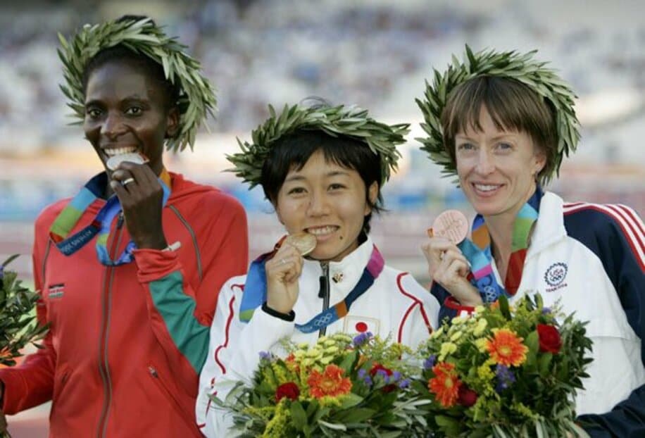  表彰式で金メダルを手に笑顔の野口氏。左は銀メダルのヌデレバ、右は銅のカスター（ロイター）