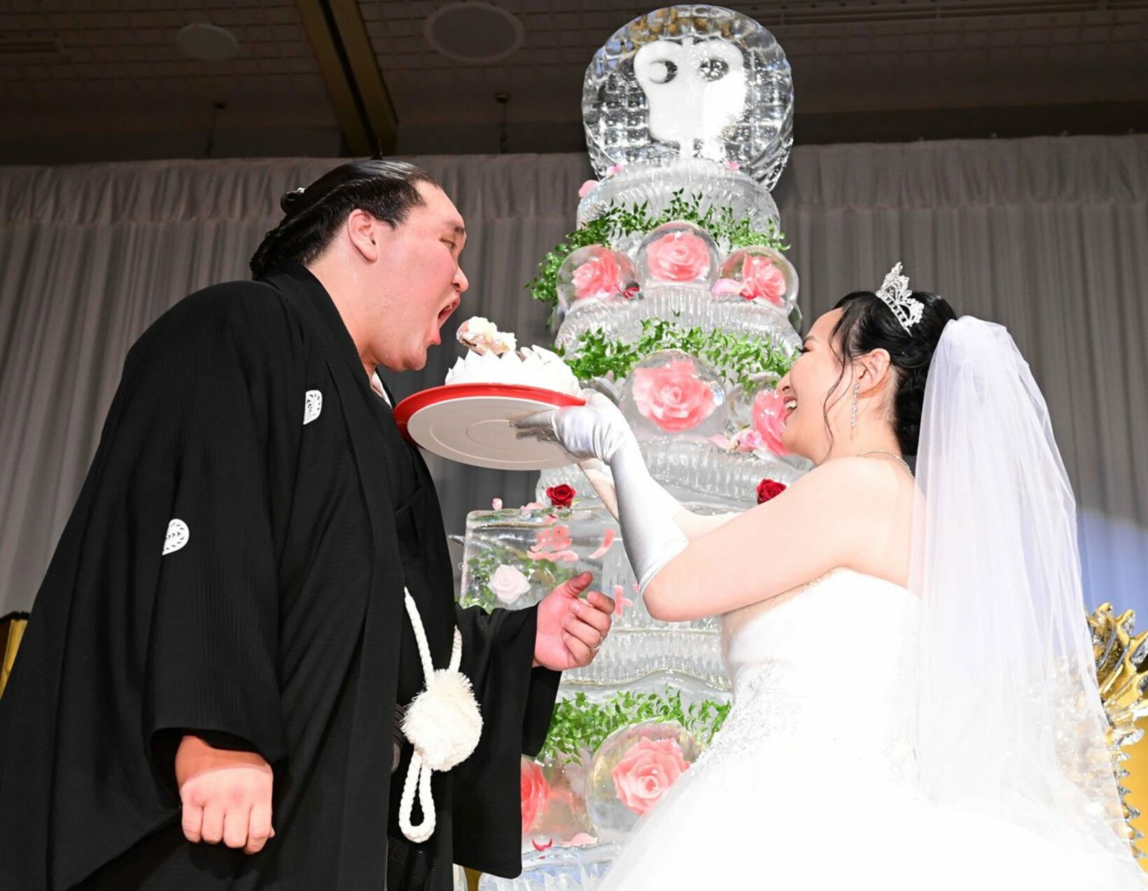 ケーキ入刀後にファーストバイトを行う照ノ富士（左）とツェグメド・ドルジハンド夫人（代表撮影）