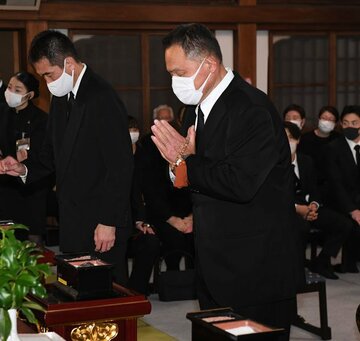  祭壇に手を合わせる山下会長