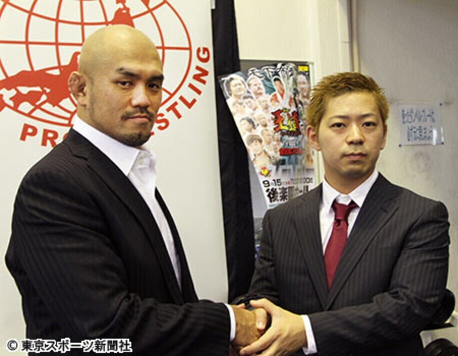 秋山社長（左）は新たに所属選手になった中島とがっちり握手