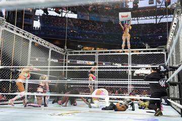 イヨ・スカイ（上）はトラッシュ缶を抱えて金網の上段へ©WWE