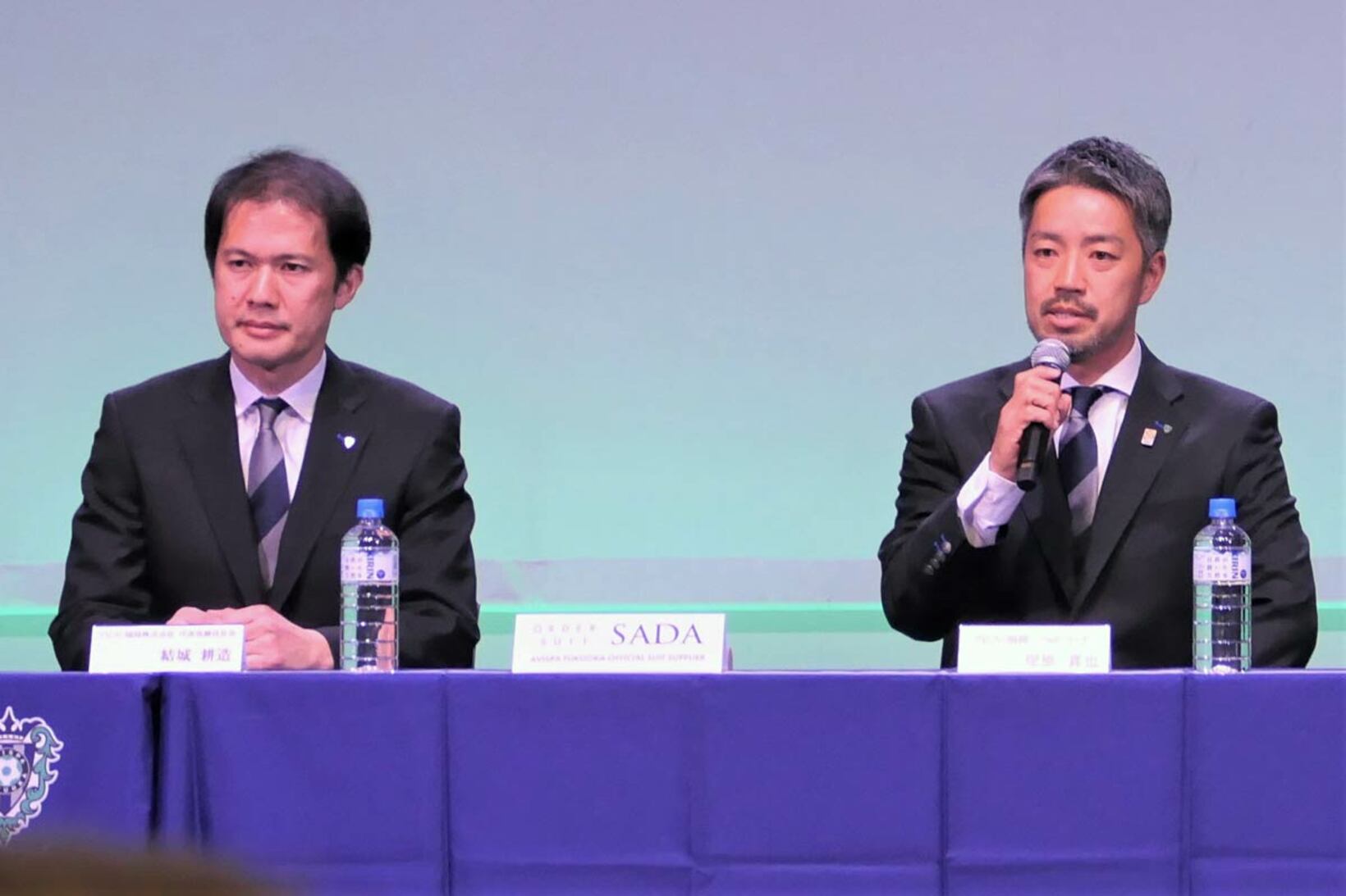 新体制発表会に出席した塚原真也ヘッドコーチ（右）と結城耕造社長