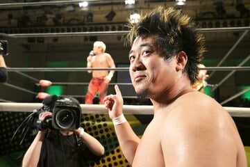 前哨戦に敗れ、苦笑いで拳王(奥)のマイクを聞いたGHC王者・稲村愛輝