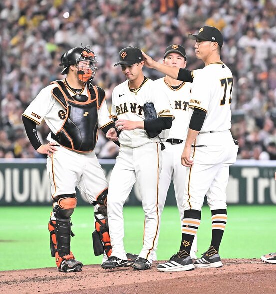 ３回途中で内海コーチ(右)にねぎらわれ、マウンドを降りる巨人・山城京平
