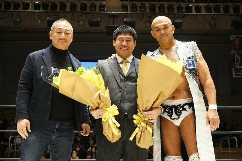 高木三四郎(左)、秋山準(右)から花束を受け取り、感極まる岡田佑介
