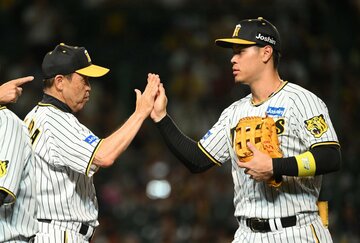 佐藤輝明（右）とタッチする岡田彰布監督