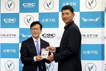 ドラフト1位の菰田陽生(右)に、サイン入りのドラフト会場入場パスを渡す日本ハム・栗山英樹CBO