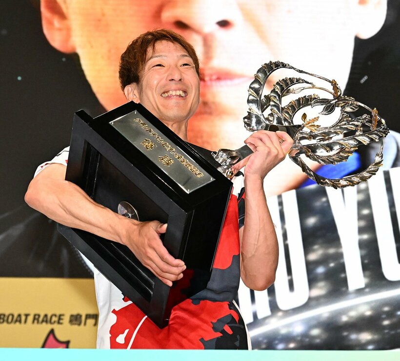 優勝し、トロフィーを持ち上げる吉田拡郎
