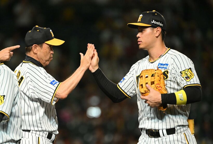 佐藤輝明（右）とタッチする岡田彰布監督