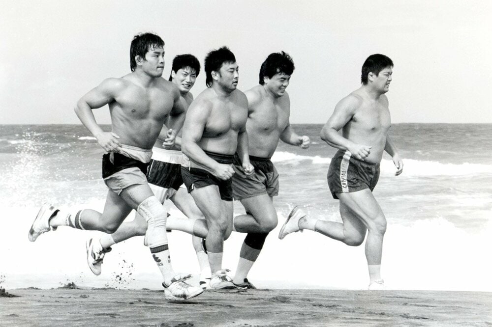 砂浜を走る超世代軍の(左から)菊地毅、小橋建太、川田利明、三沢光晴、田上明(90年8月)