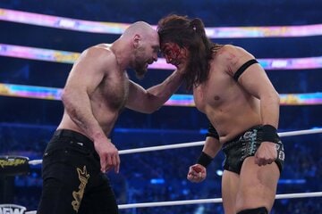 血だるまになりながら、ジョン・モクスリー（左）と頭を突きつけ合う竹下幸之介 ©All Elite Wrestling