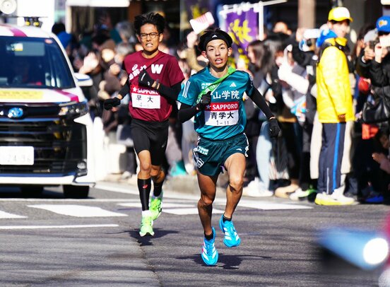 往路５区で早大・工藤(左)を抜き去り、トップに躍り出た青学大・黒田朝日（代表撮影）