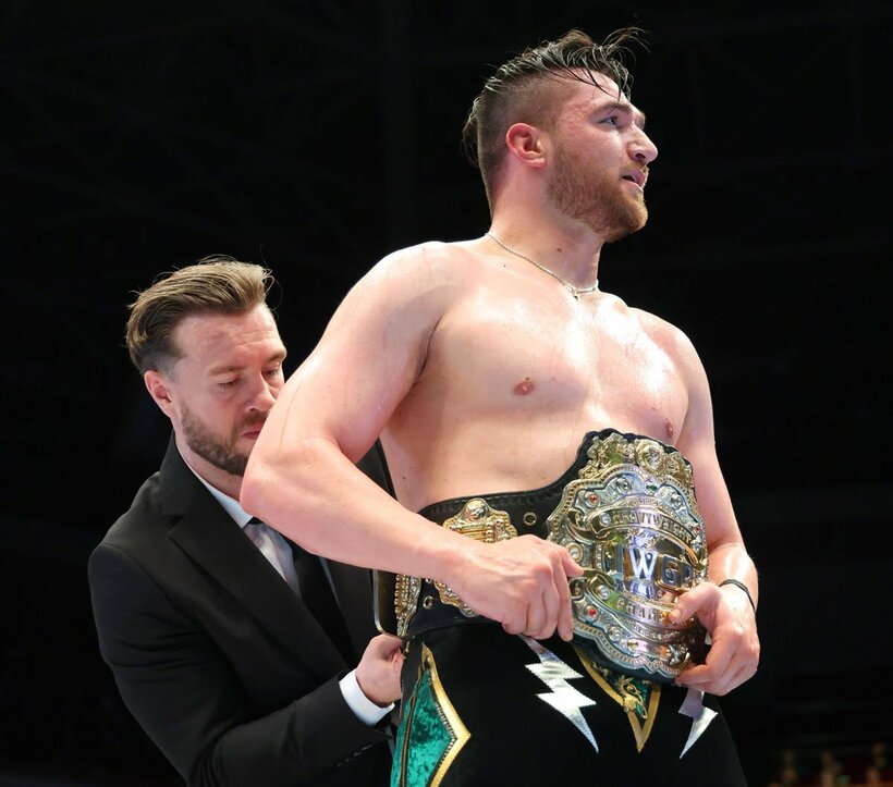 カラム・ニューマンにベルトを巻くウィル・オスプレイ