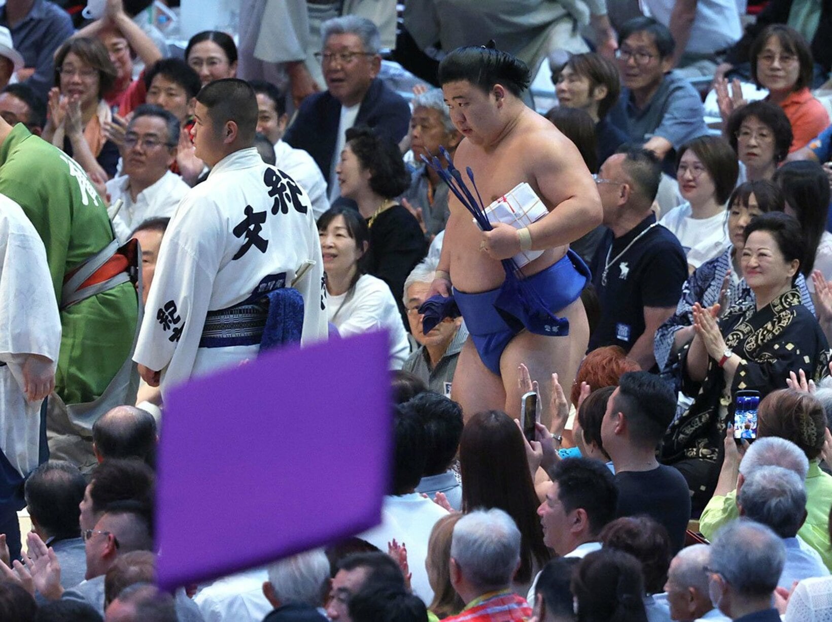 座布団が舞う中、多額の懸賞を手に引き上げる藤ノ川