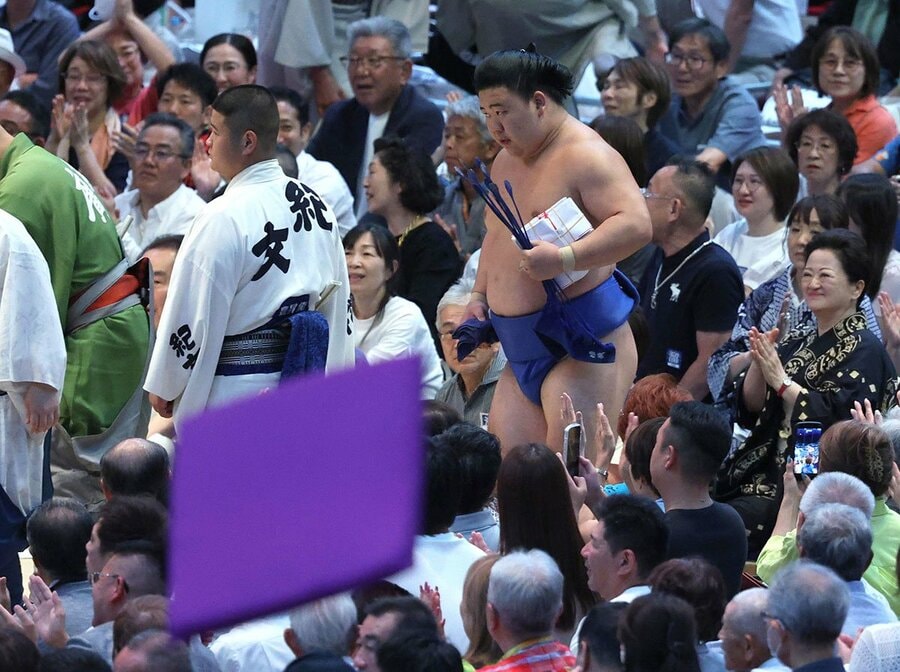 座布団が舞う中、多額の懸賞を手に引き上げる藤ノ川