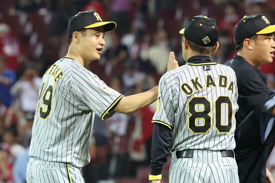 試合に勝利し岡田監督（右）とタッチする阪神・大竹