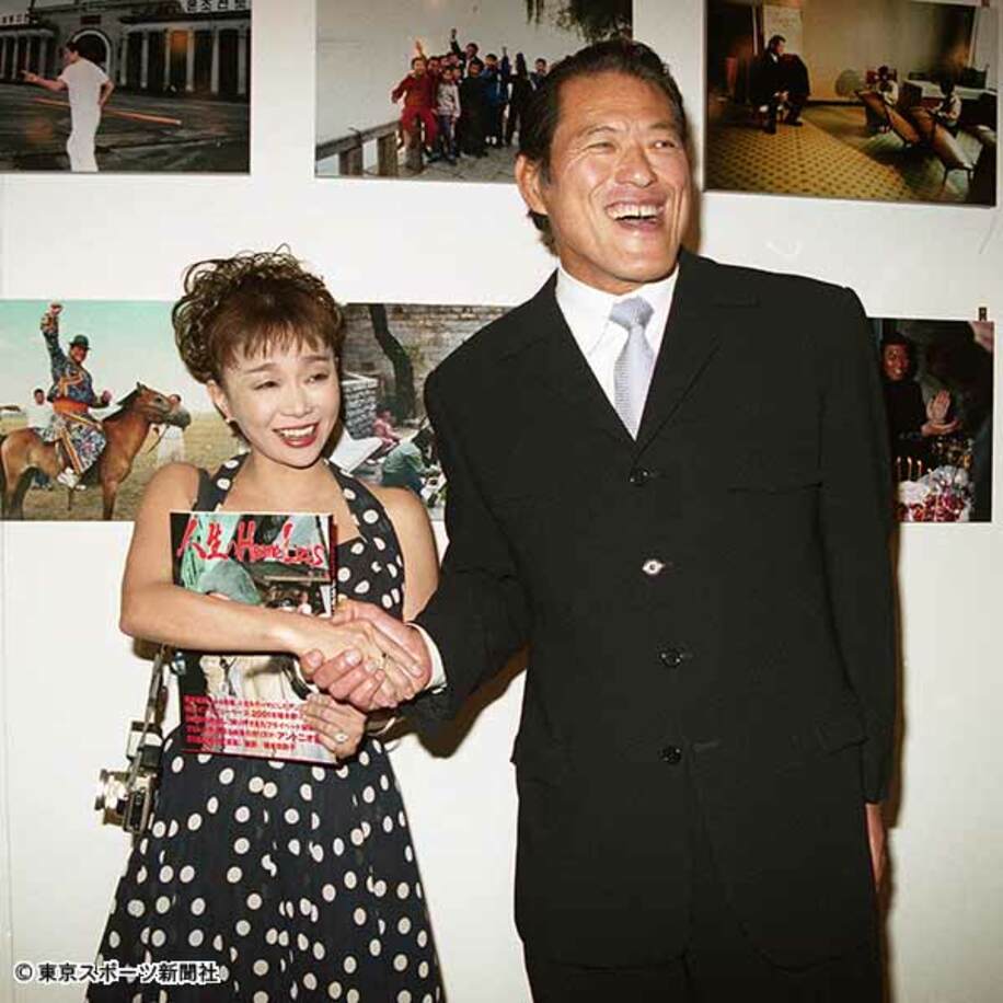  ０１年５月の写真集出版記念パーティーで握手する猪木氏と田鶴子さん