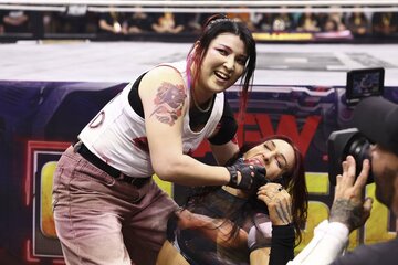 志田光（左）はクリス・スタットランダーの口にリンゴを突っ込む   ⒸAll Elite Wrestling