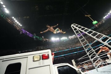 男子MITBラダー戦でブロン・ブレイカー（右下）にラダーを倒され救急車の天井に落下するジェボン・エバンス©WWE