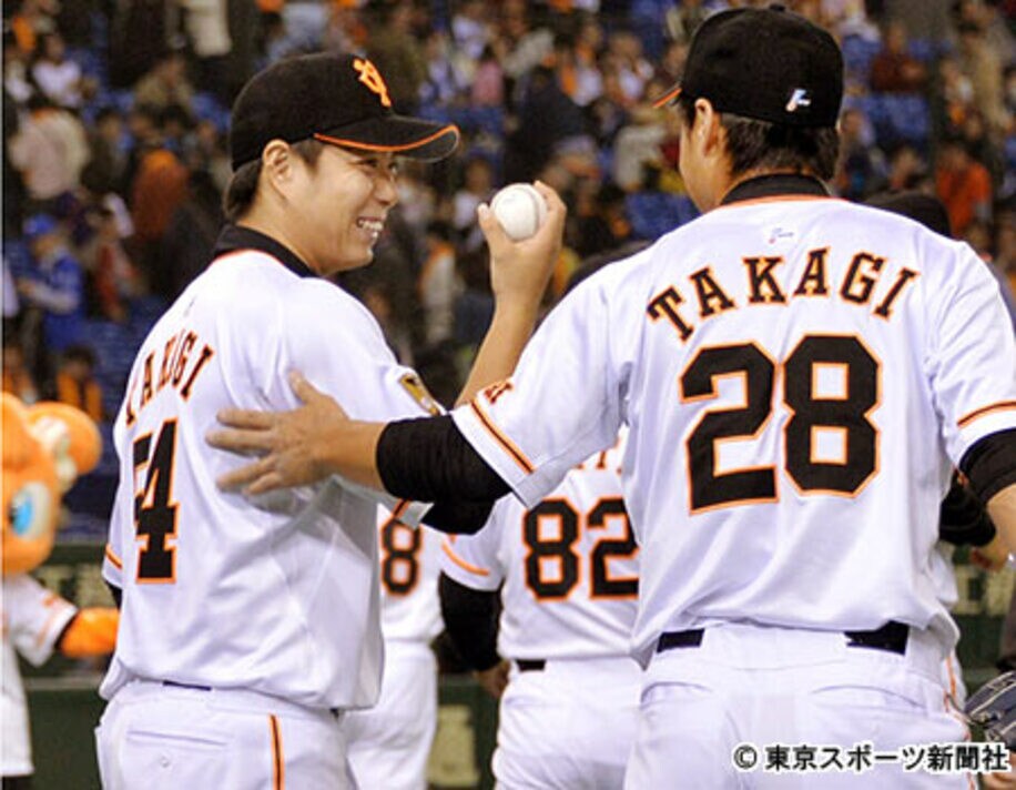 高木京介（右）からウィニングボールを受け取り、笑顔の高木勇