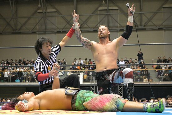 勝ち名乗りを受けるデビッド・フィンレーと倒れ込んだままの高橋ヒロム