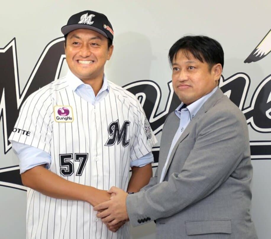  松本球団本部長（右）と笑顔で握手する澤村(代表撮影)