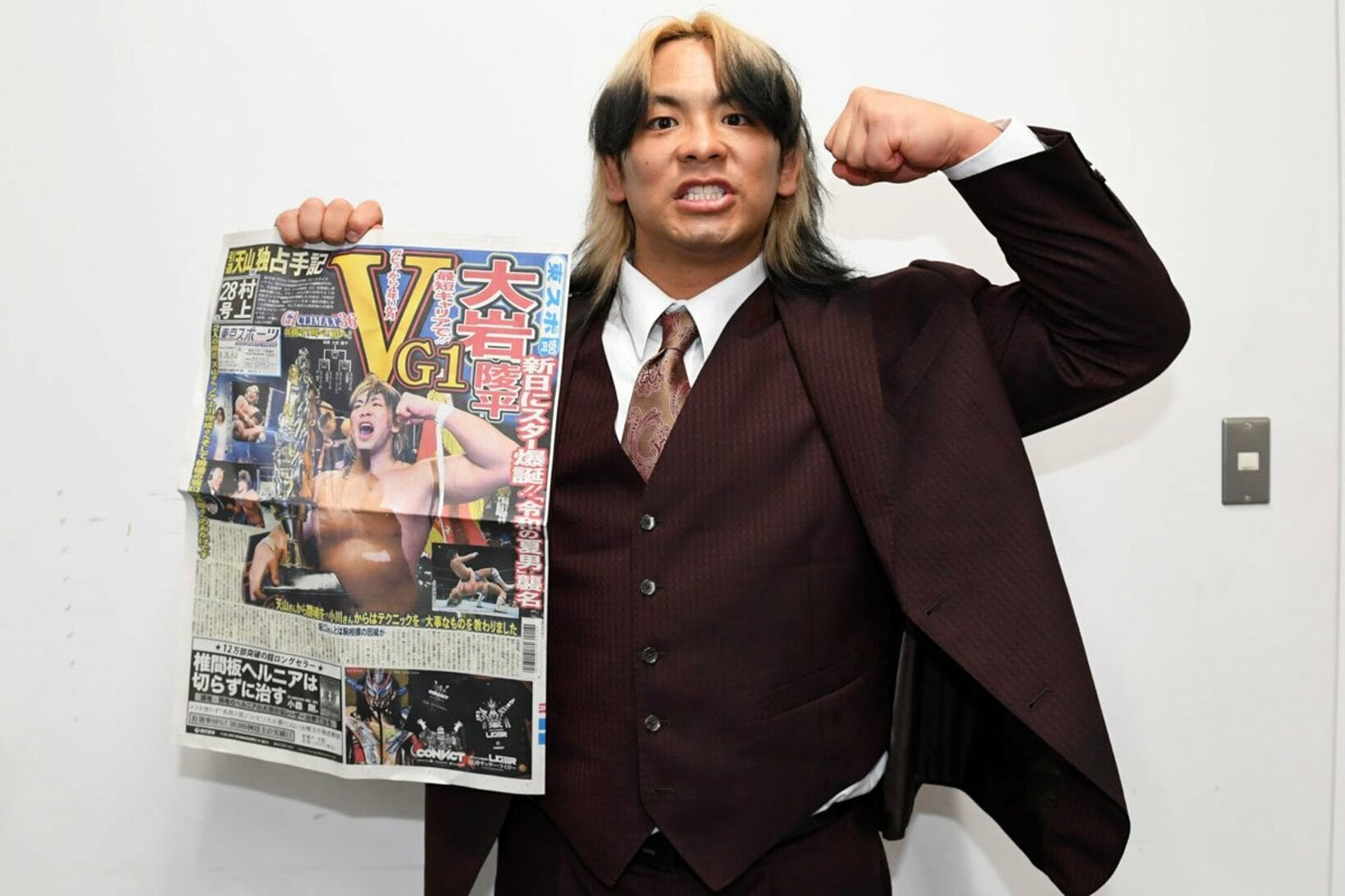 優勝を報じる本紙１面を手にガッツポーズの大岩陵平