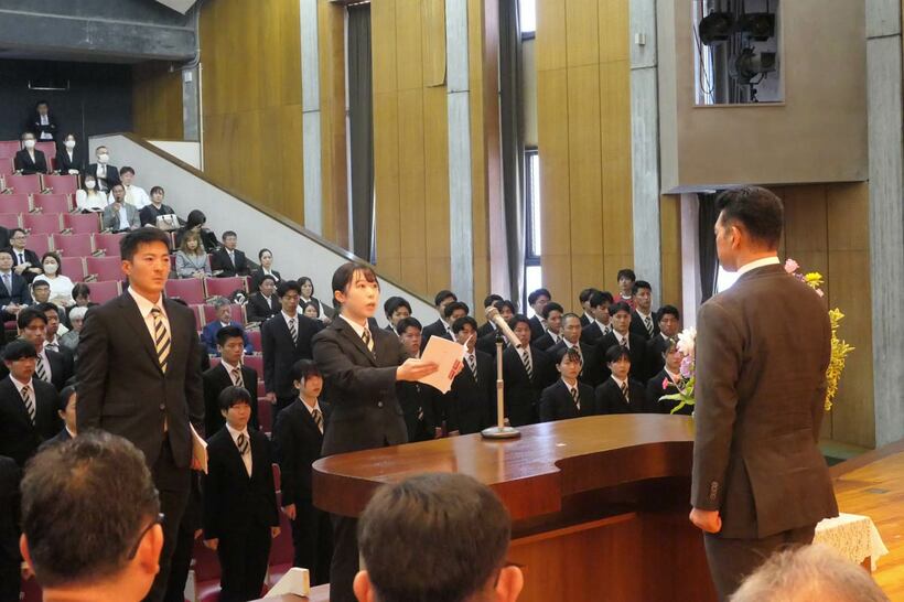 神山雄一郎所長（背中）を前に誓いの詞を述べた金子梨亜候補生と佐藤文彦候補生