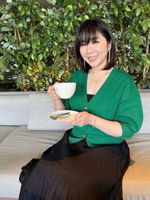 コーヒーカップを手にほほえむ岡本真夜