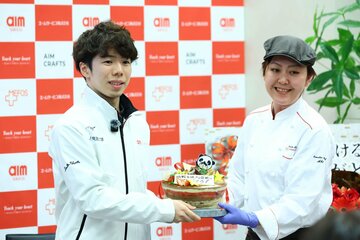 所属先のエームサービスから、ケーキのプレゼントを受け取った佐藤駿(左)