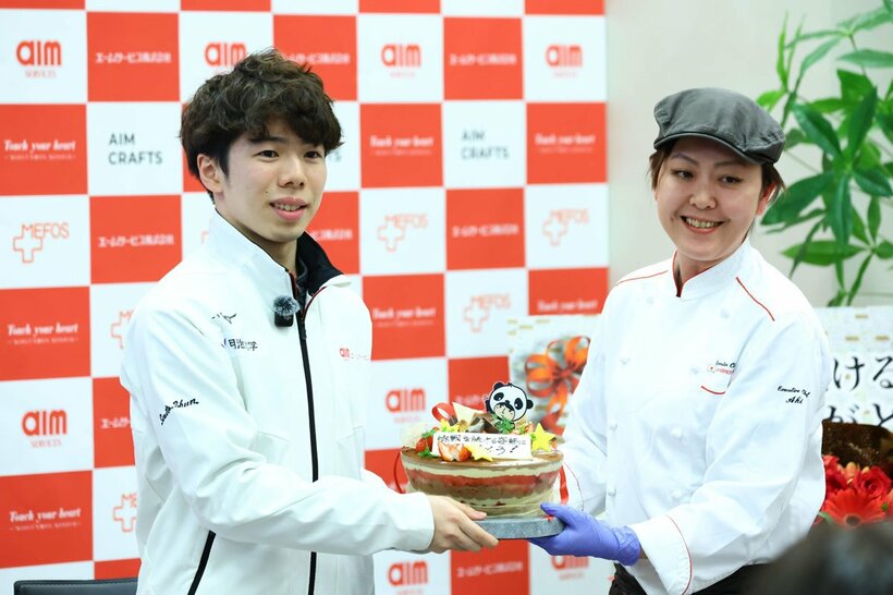 所属先のエームサービスから、ケーキのプレゼントを受け取った佐藤駿(左)