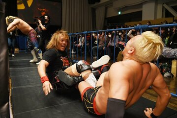  場外でオカダ(右)に四の字固めを決め、ドヤ顔の内藤