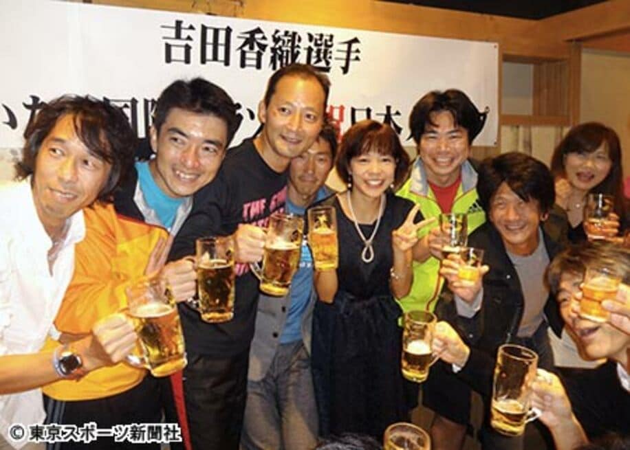 ランナー仲間と祝杯を挙げる吉田（左から５人目）