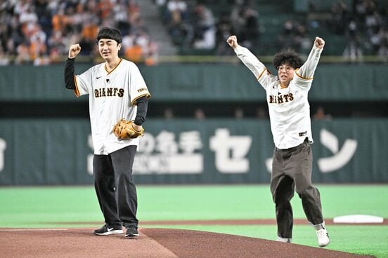 始球式でノーバン投球を見せ、ガッツポーズのたくろう・赤木裕(左)と喜ぶきむらバンド　