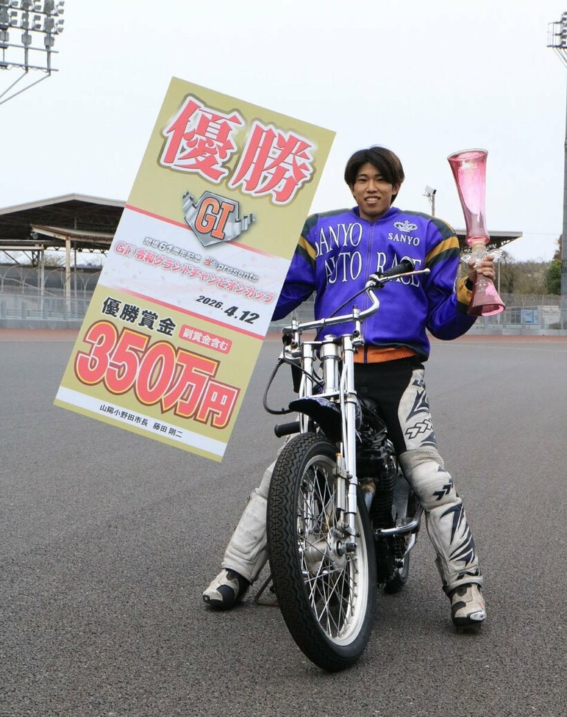 優勝した長田稚也は賞金ボードとトロフィーを手に笑顔