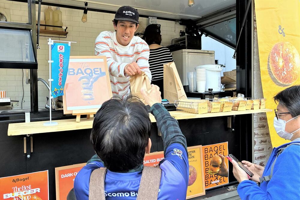 キッチンカーから商品を手渡しする木戸皓貴さん