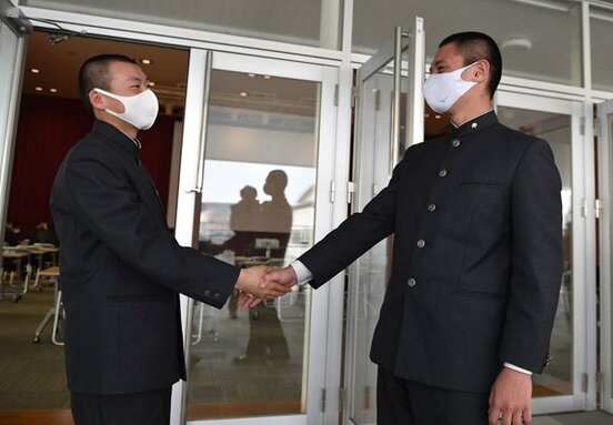  抽選会が終わり、チームメートの川本(左)と握手する福大大濠・毛利