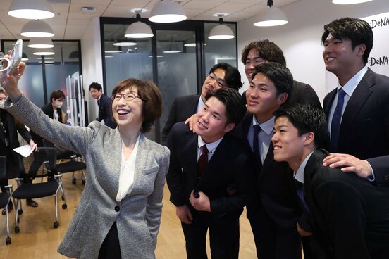 ６人のルーキーと記念写真を撮る南場智子オーナー