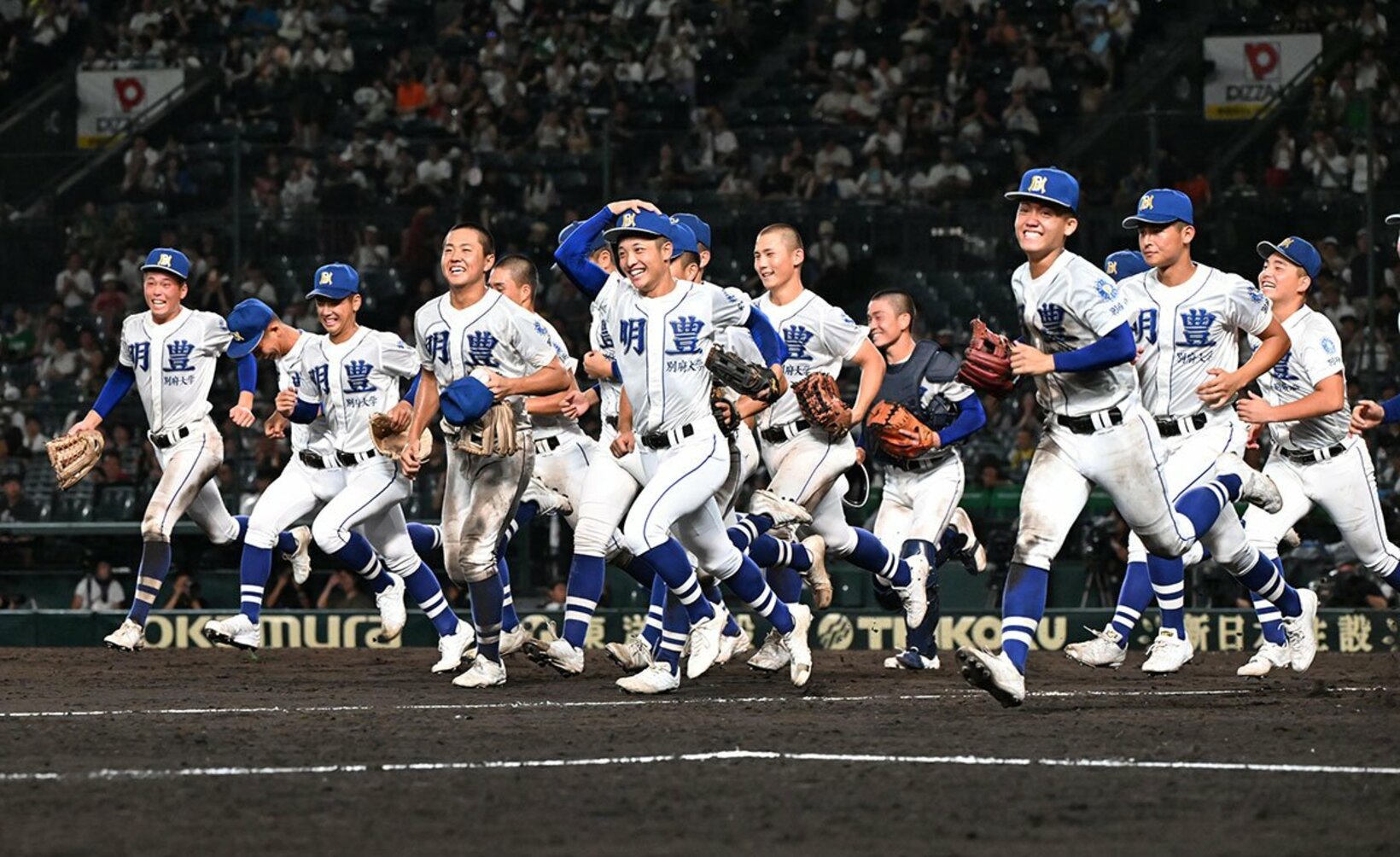 初戦突破を決め、笑顔でアルプスの応援団の元へ駆け出す明豊ナイン