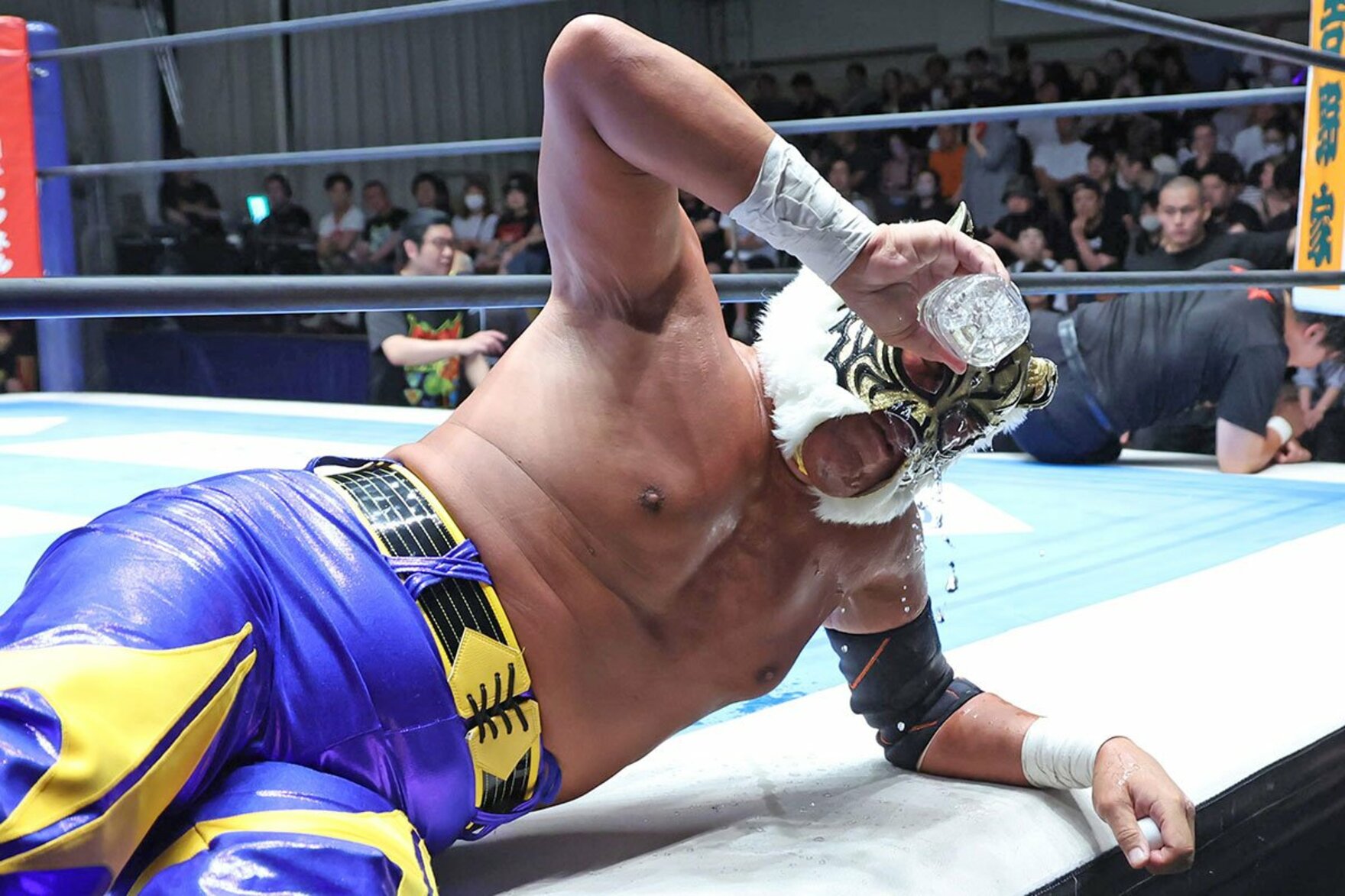 噴射されたウイスキーを水で洗い流すタイガーマスク　