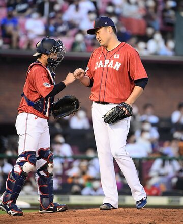  捕手の阪神・梅野(左)とグータッチする楽天・田中将